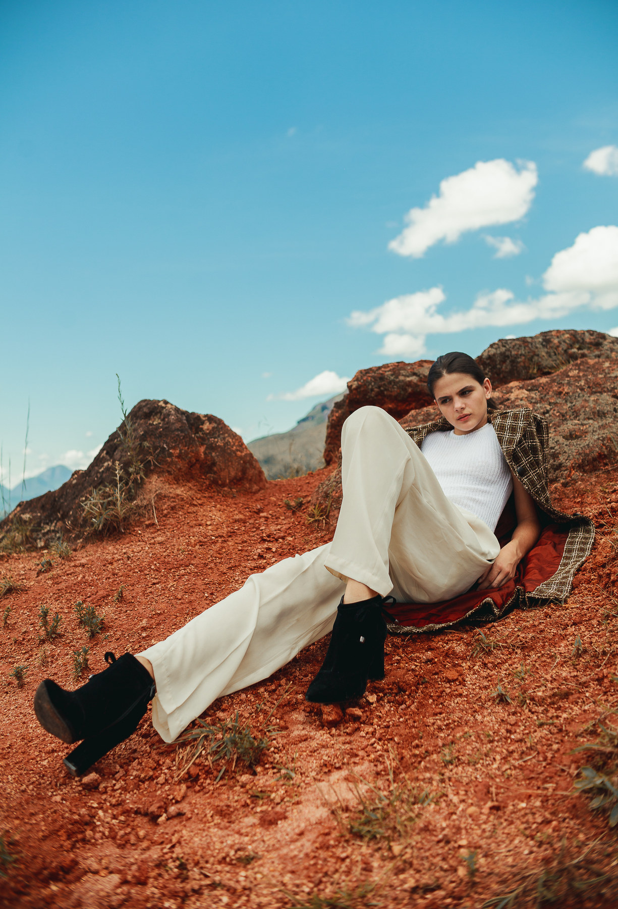 Editorial auf rotem Felsplateau, Model in weiter Hose