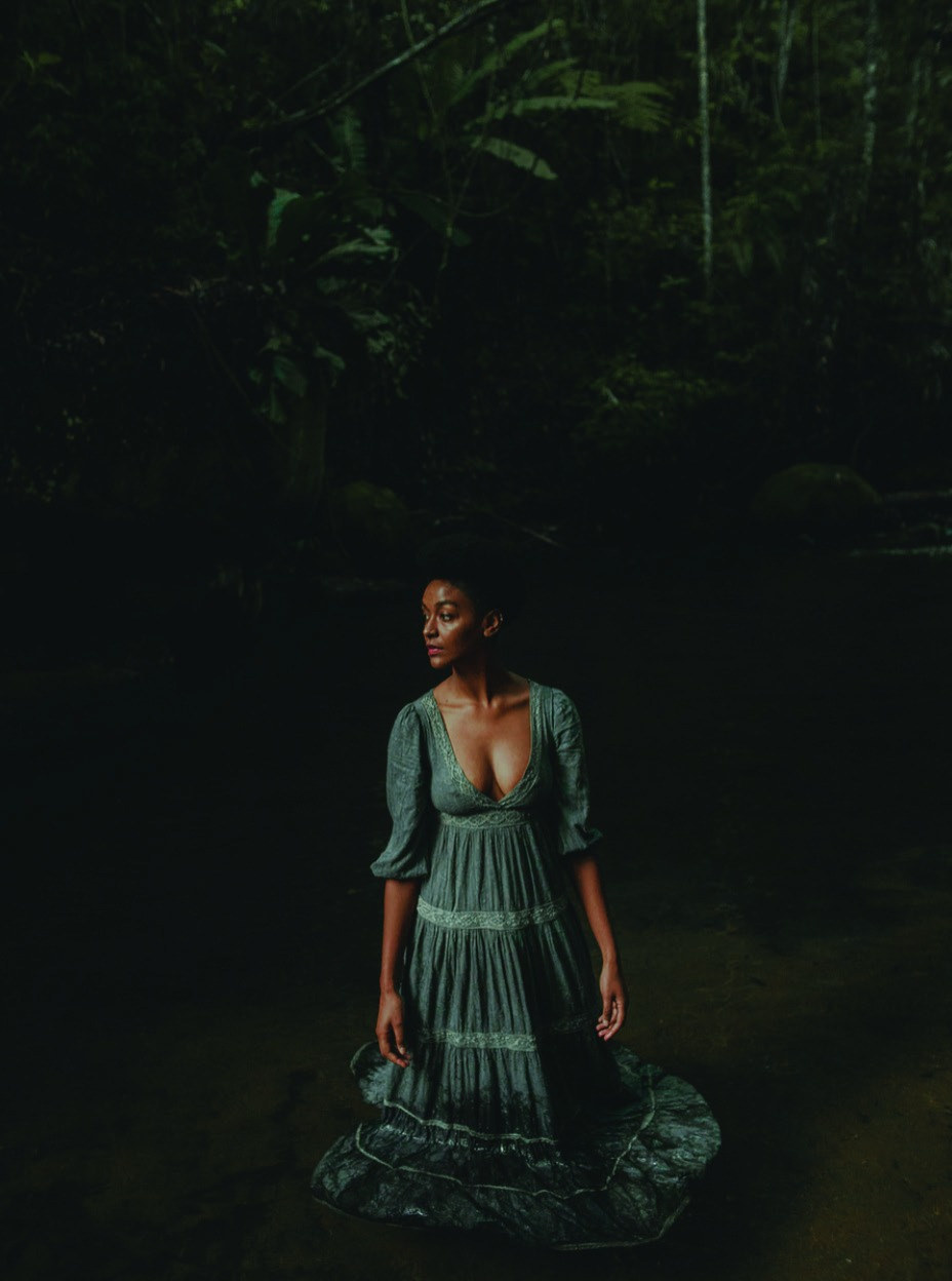 Model im langen Kleid im Regenwald-Wasserlauf
