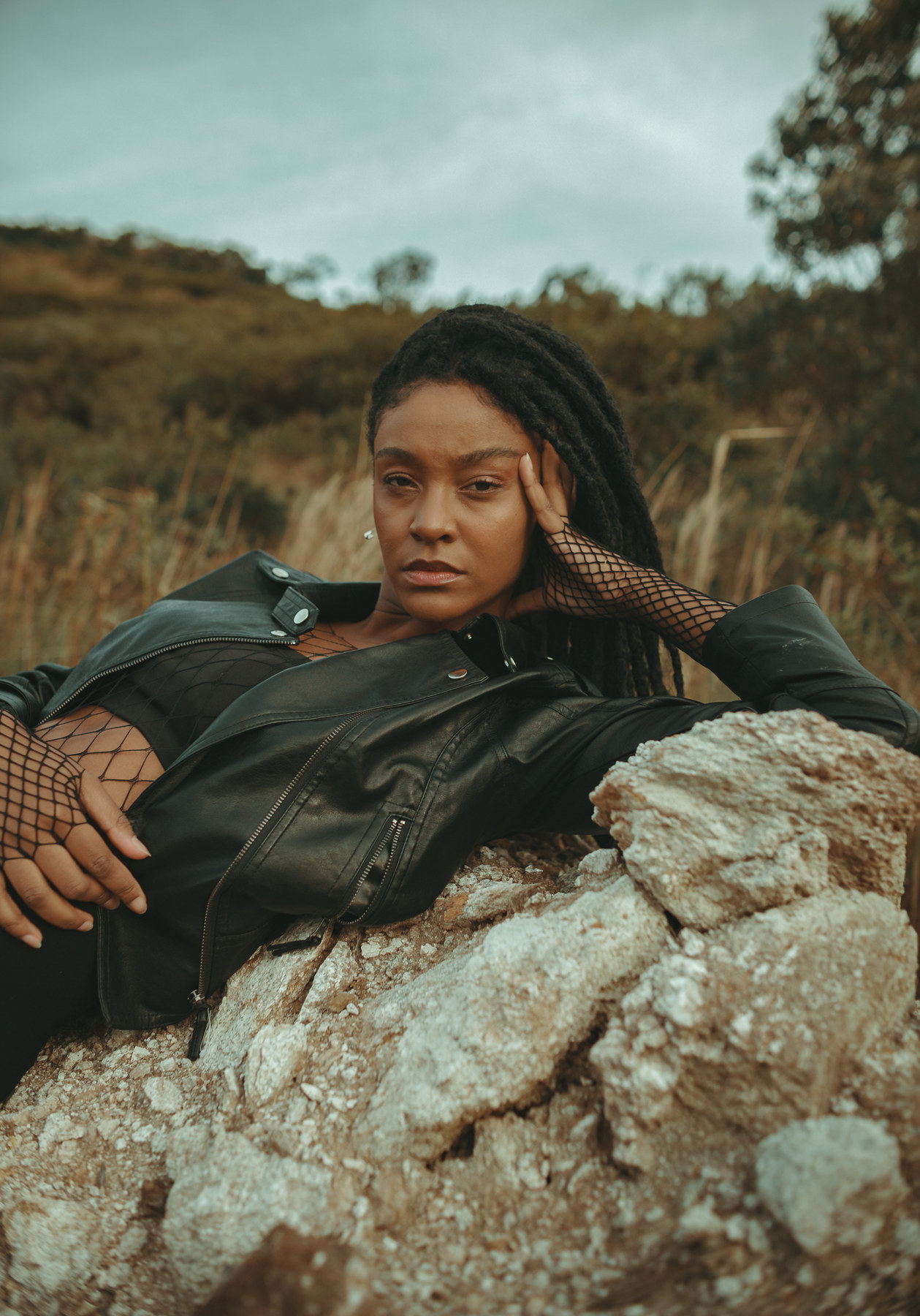 Editorial mit Lederjacke auf Felsen