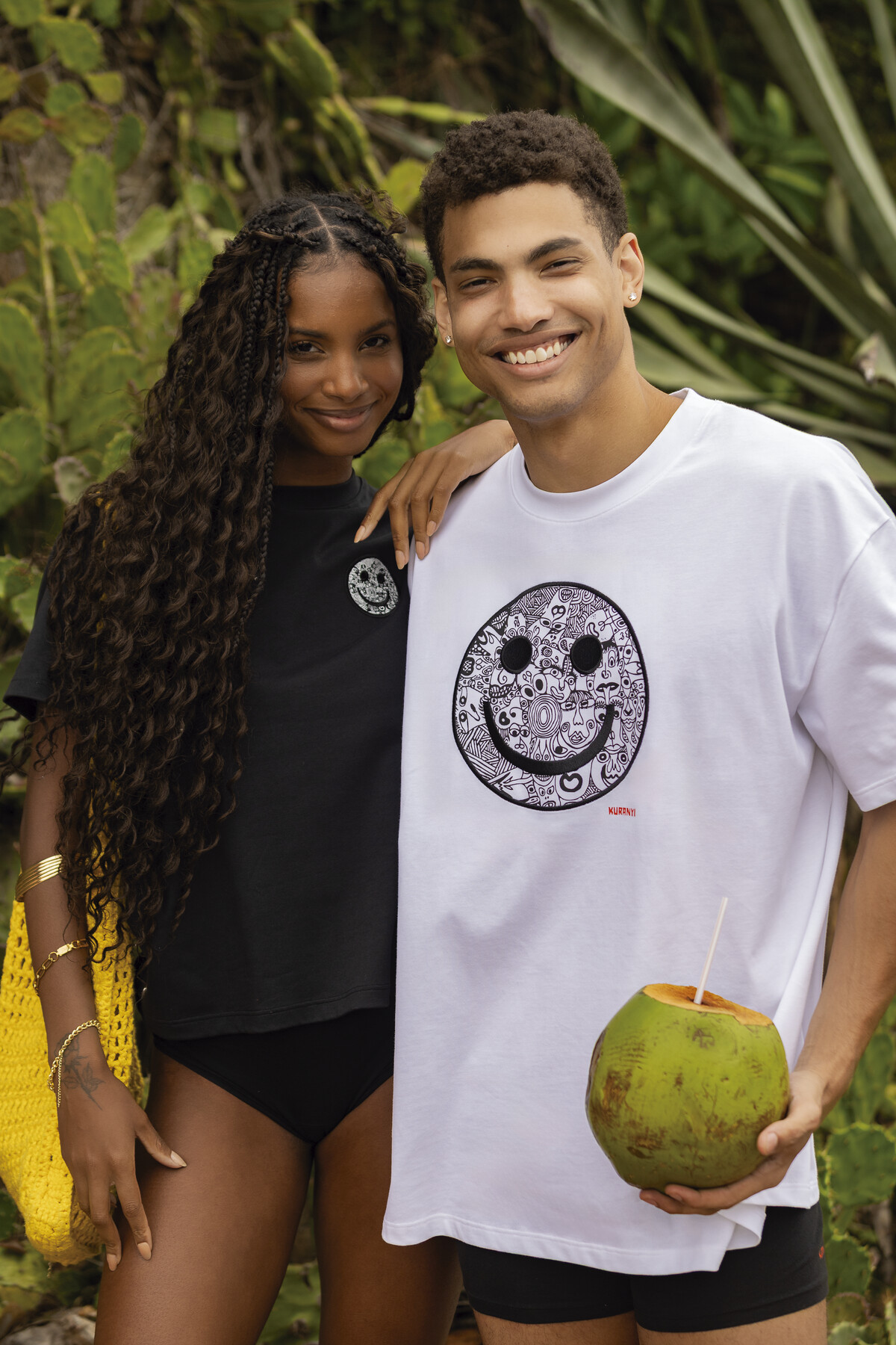 SKINY × KURANYI Kampagne — Paar mit Kokosnuss und Smiley-Shirt