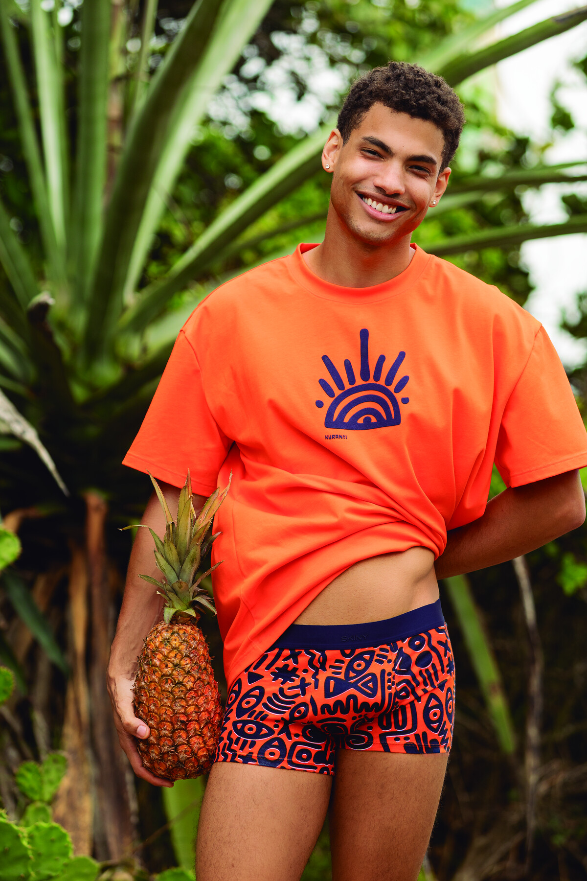 SKINY × KURANYI Kampagne — Model mit Ananas in Orange